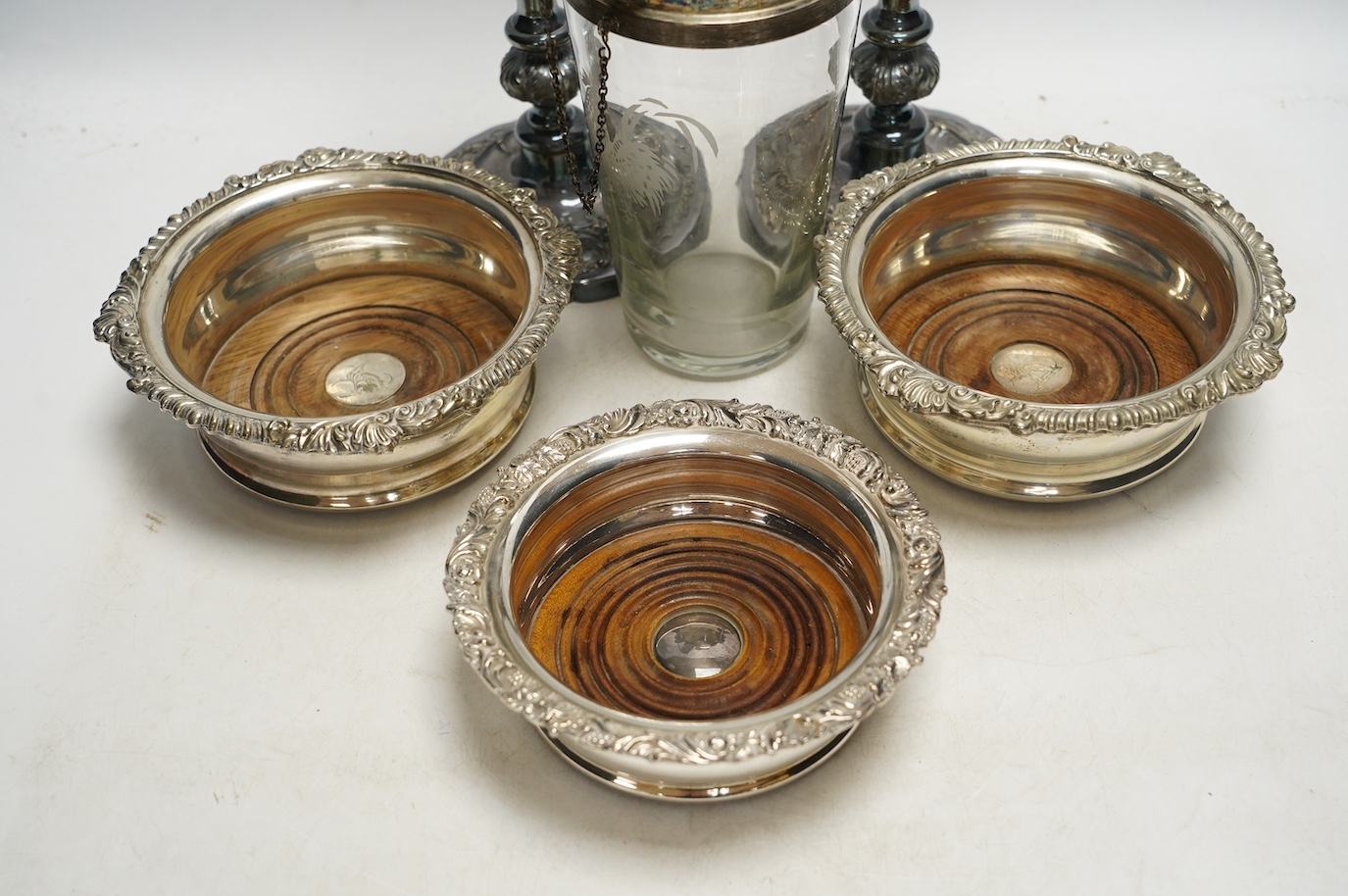 A pair of silver plated candlesticks, a pair and another wine coaster, and a cocktail shaker, tallest 25cm. Condition - fair